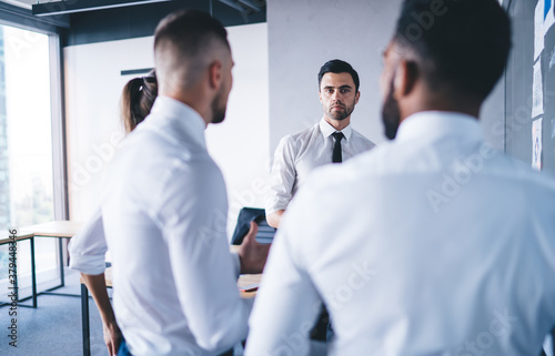 Focused multiracial coworkers discussing business issue and work plan in office
