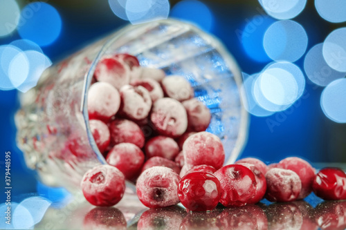 Frozen cherry in the glass reflecting on the surface with blurred background
