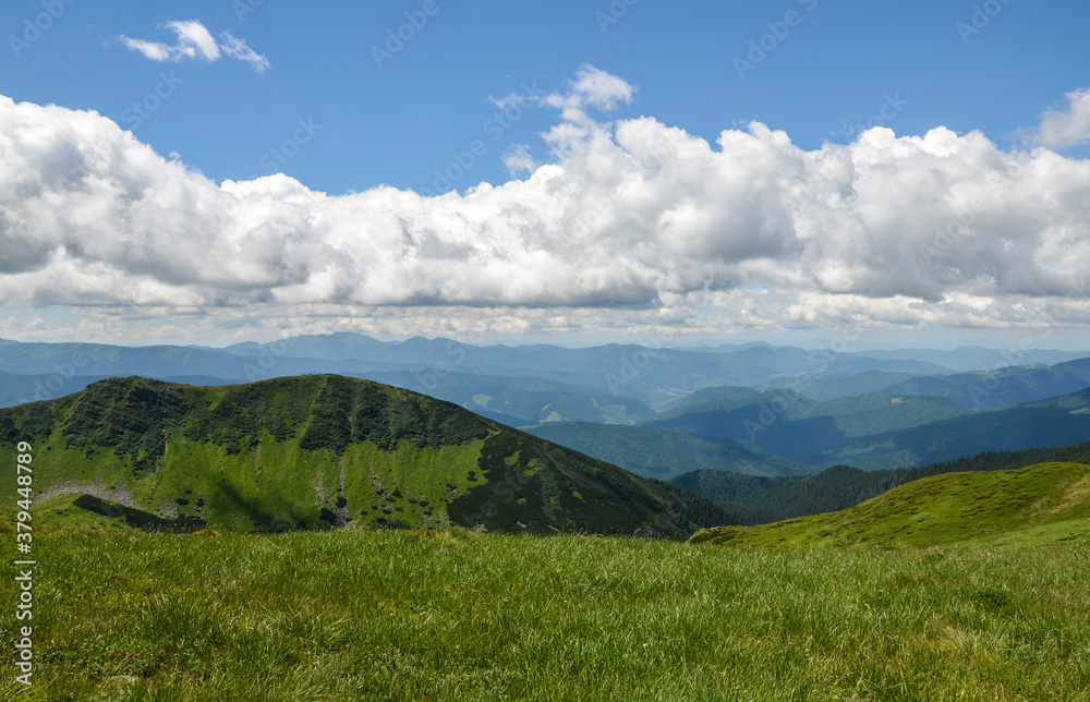 Landscape view of green hills of chornohora ridge. Sunny weather with clouds on the blue sky. Beautiful scenery of Carpathian mountains