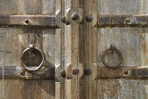 Closeup of Old Rustic Wooden Door with Metal Ring Handles