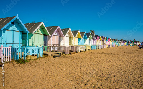 Obraz na płótnie A wide-angle view along brightly coloured beach huts on West Mersea beach, UK in