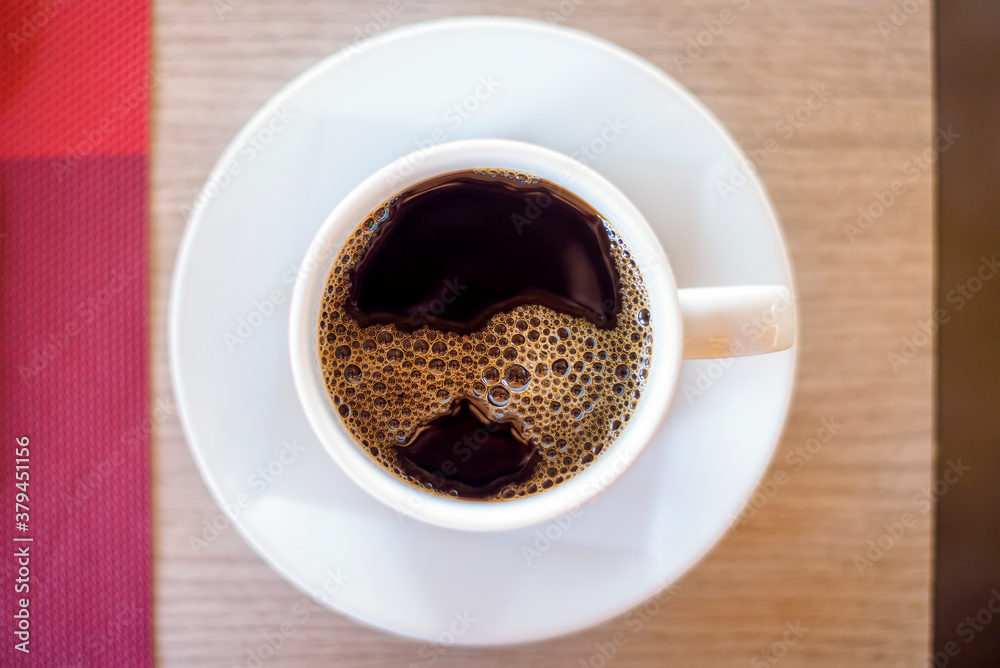 top view of cup of hot black coffee on wooden table background top view of cup of hot black coffee on wooden table background