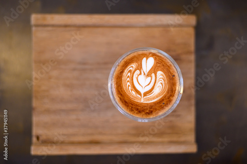 top view of cup of hot latte art on wooden table background