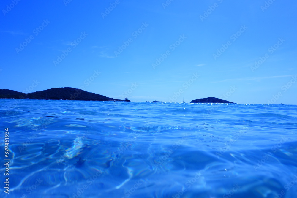 Dilemma zwischen Kristallklarem Meerwasser und Booten am Horizont.