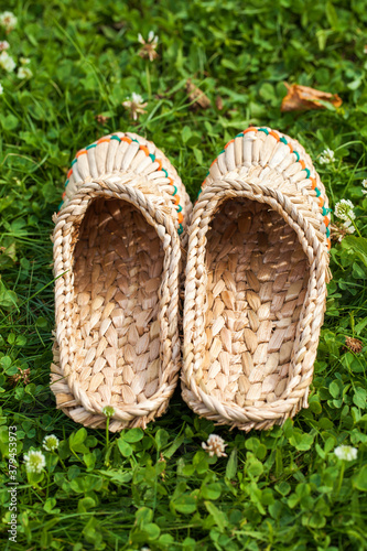 Braided bark sandals on the background of green grass