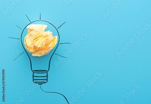 Sketch lamps and crumpled yellow paper on a blue background. Concept picture about office work and   creativity ideas. 
