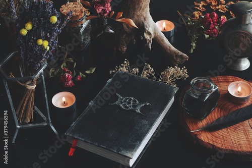 Tableau sur toile Wiccan witch altar with hand made old looking book grimoire with triple moon sym