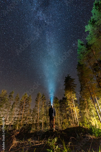 Man looking at the Milky way with a head lamp