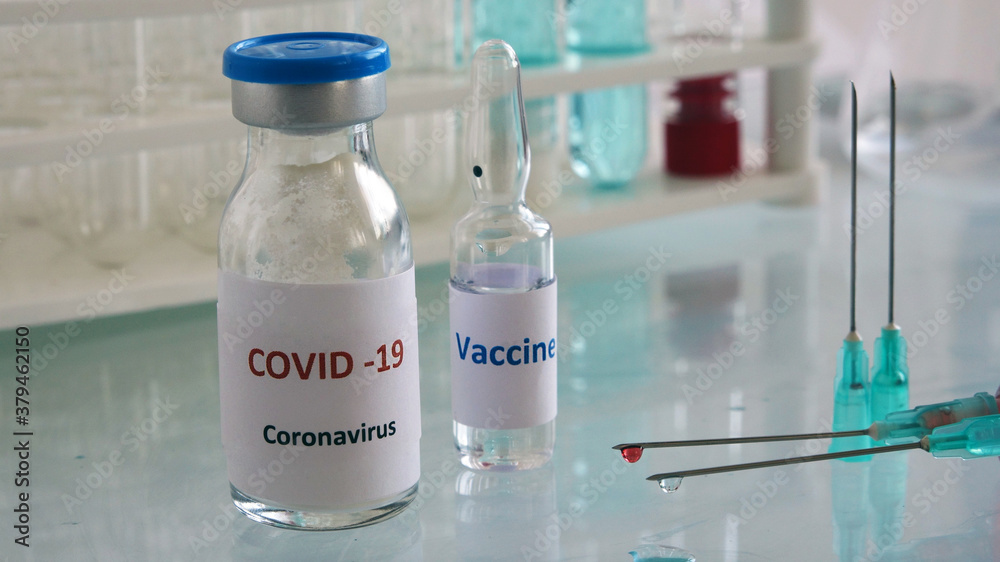 Mini medicine glass bottle and injector with medical materials on the glass table.Vaccine works in the laboratory.Selective focus Mini medicine glass bottle and injector with medical materials on the glass table.Vaccine works in the laboratory.Selective focus