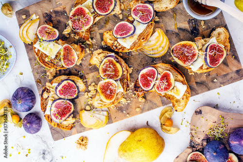 view of delicious freshly baked croissants with figs, pears, nuts and honey