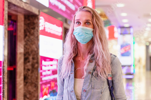 Young blond woman in mask at the mall. Coronavirus pandemic. Moscow, Russia, 09/21/2020.