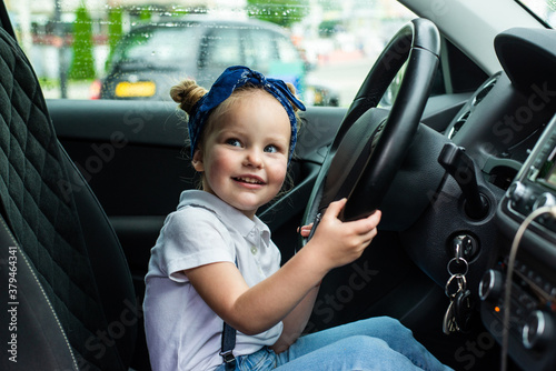 Cute little girl in car behind the wheel