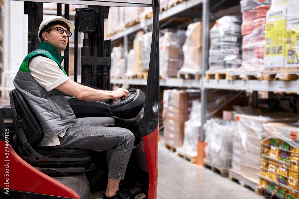 Fototapeta premium professional warehouse worker sit inside of machine, doing logistics, check