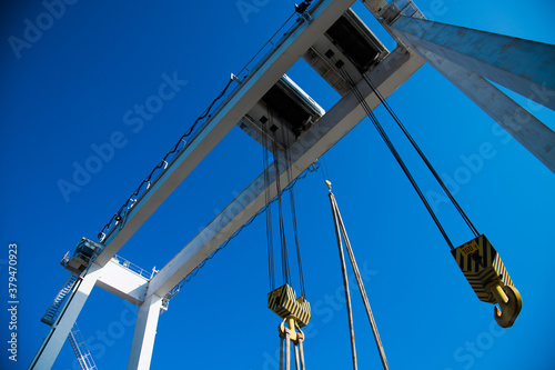 Harbor gantry crane moving a tank container photo