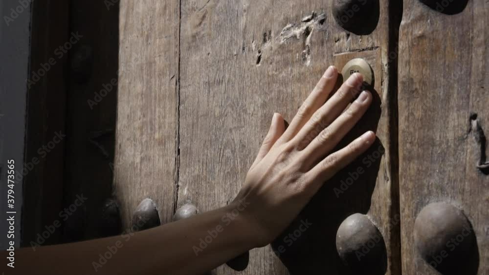 Mano de mujer blanca joven acariciando una puerta de madera antigua HD