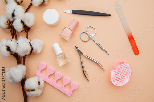 Beauty care. Tools for creating and for the treatment of nails on pink table. Top view.