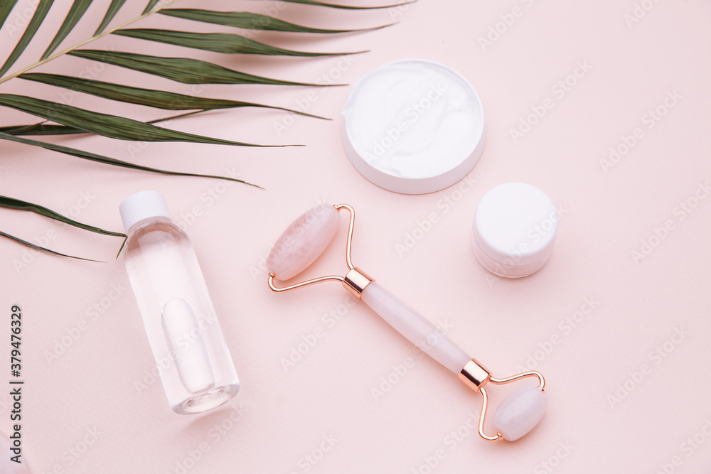 Modern apothecary or home spa composition on pink background. Jade roller for face massage. Selfcare, relaxation and beauty care. Modern apothecary or home spa composition on pink background. Jade roller for face massage. Selfcare, relaxation and beauty care.