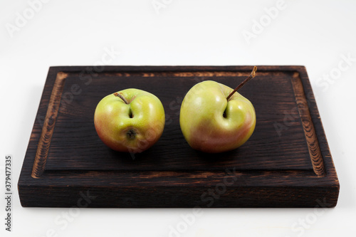 Ugly fruits. Two green apples with flaws on a dark wooden cutting board.  Selective focus, copy space. Concept - Food waste reduction. Using in cooking imperfect products photo