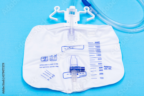 Sterile Urinary Drainage Bag with Anti-Reflux Tower isolated on blue background. © bjphotographs