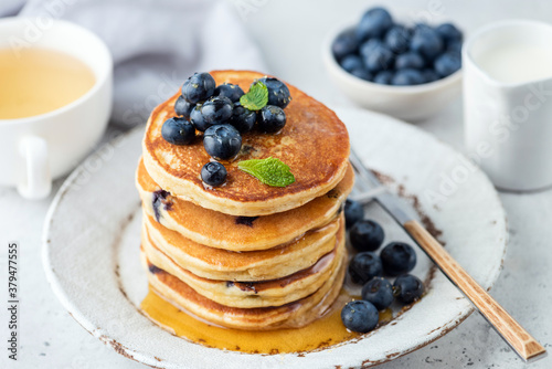 Pancakes with blueberries and honey on a plate. Breakfast pancakes stack with berries