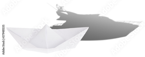 concept with light origami boat and modern yacht shadow on white