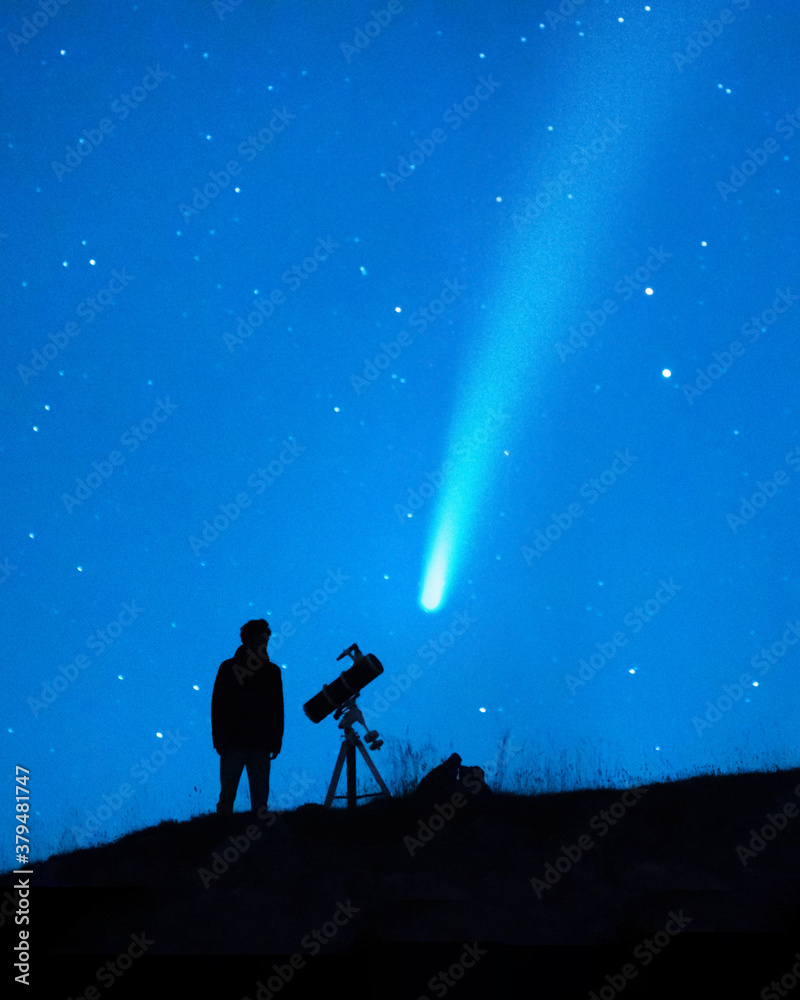 Astronomy lover with a telescope observing a comet in the blue starry sky at night. Silhouette of a person observing the immensity of the universe and the stars. Trace of a comet or a shooting star.