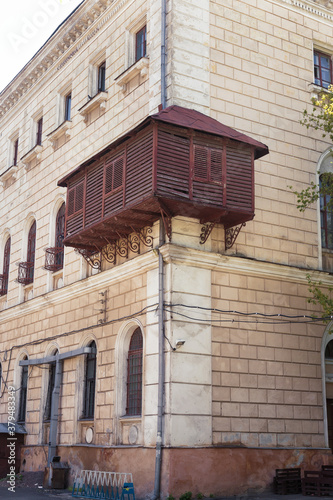 ODESSA, UKRAINE - May 31, 2019: Antique wooden balcony with closed shutters. Ancient house in Odessa, Ukraine Views of Odessa in retro style.