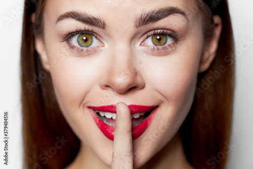 Close-up portrait of woman holding finger near lips 