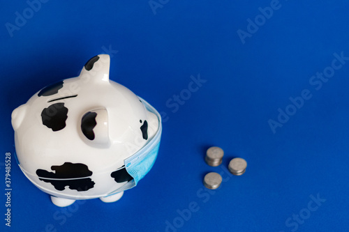 piggy bank with dollars and a face mask to prevent coronavirus covid-19