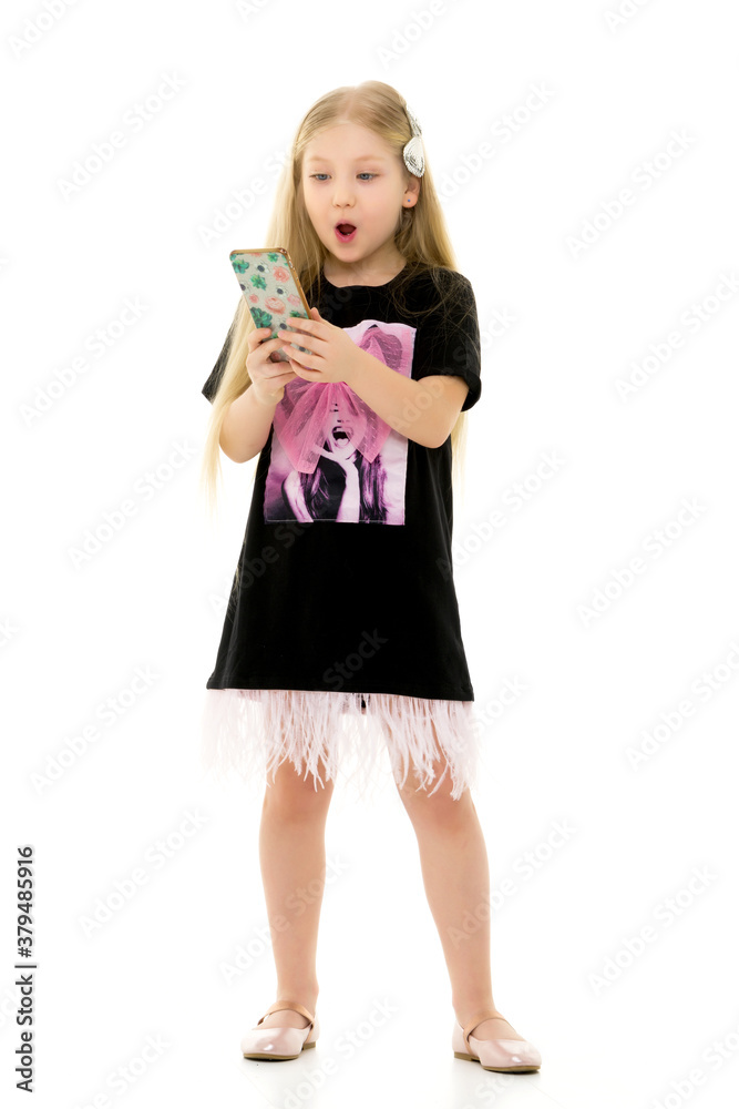 The girl is using a cell phone.The concept of people and technology. The girl is using a cell phone.The concept of people and technology.