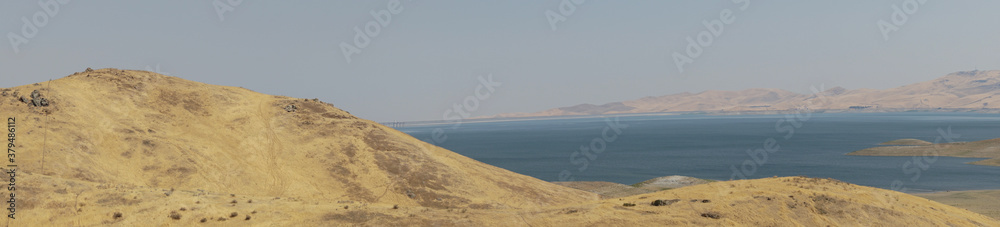 The San Luis Reservoir during dry and hot season, artificial lake on San Luis Creek in the eastern slopes of the Diablo Range of Merced County, California. USA The San Luis Reservoir during dry and hot season, artificial lake on San Luis Creek in the eastern slopes of the Diablo Range of Merced County, California. USA