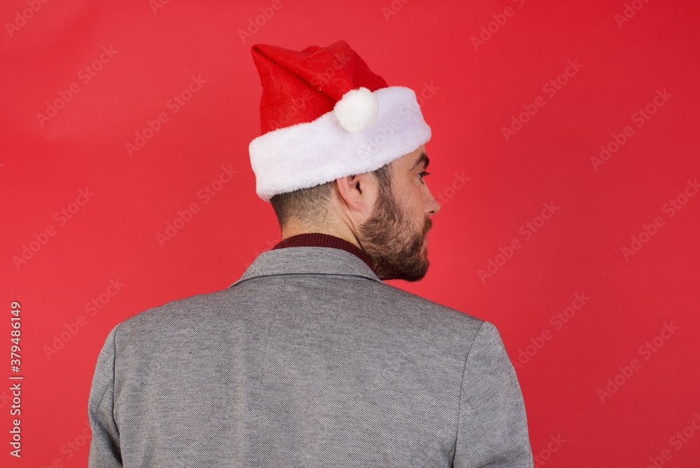 The back side view of a Young caucasian businessman wearing casual clothes standing over isolated red background Studio Shoot. The back side view of a Young caucasian businessman wearing casual clothes standing over isolated red background Studio Shoot.