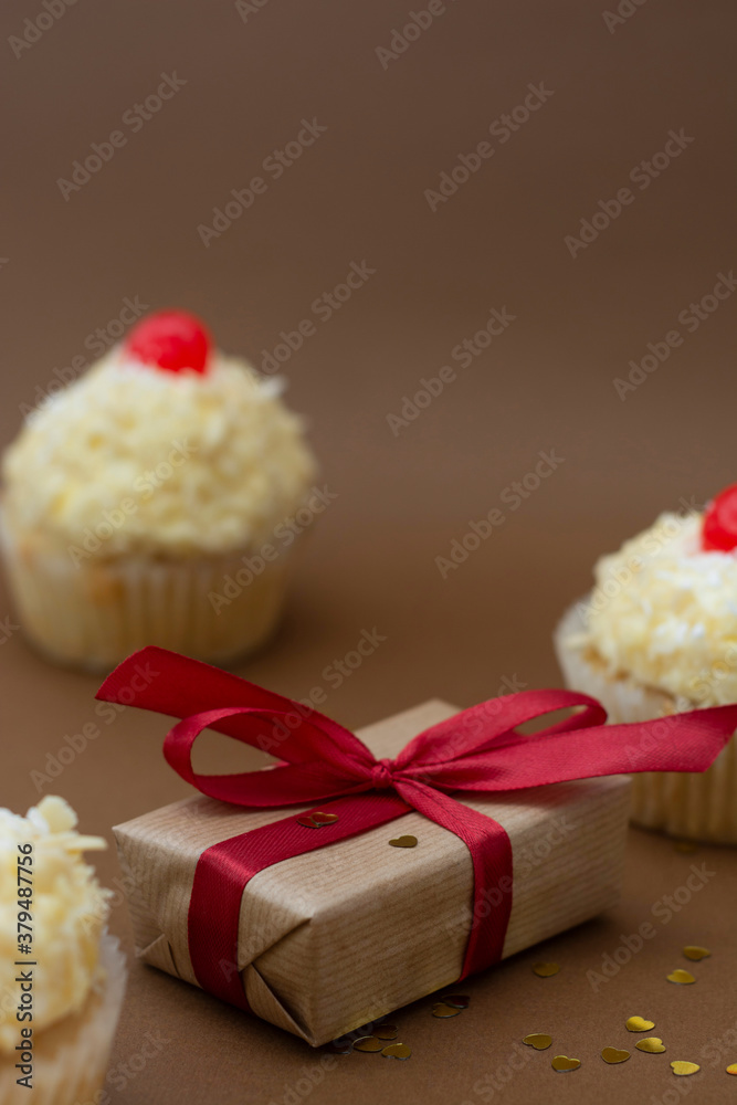 Gift boxes and vanilla cupcakes with cherry on top. Birthday concept. Sweet dessert with copy space. Gift boxes and vanilla cupcakes with cherry on top. Birthday concept. Sweet dessert with copy space.