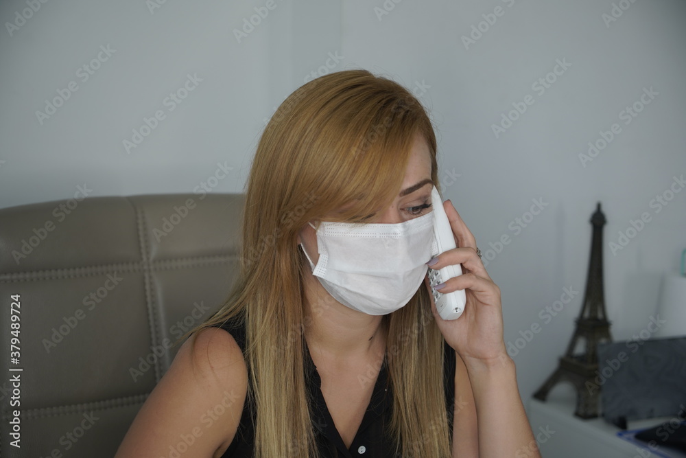 Portrait of blonde business woman in face mask talking on mobile phone, smartphone in female hand close up. Concept of communication during coronavirus pandemic Portrait of blonde business woman in face mask talking on mobile phone, smartphone in female hand close up. Concept of communication during coronavirus pandemic