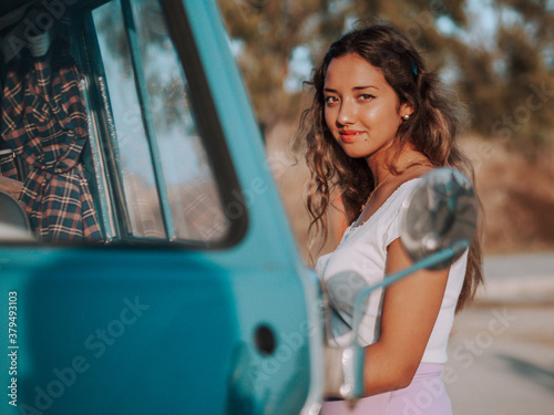 Mujer joven con una furgoneta azul