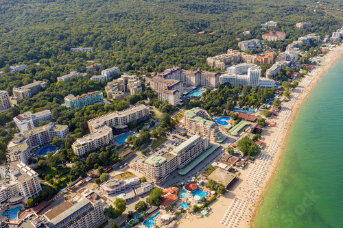 Aerial image a drone resort Golden Sands on Black Sea coast in Bulgaria. Many hotels and beaches with tourists, sunbeds and umbrellas. Sea travel destination. Travel and vacation concept