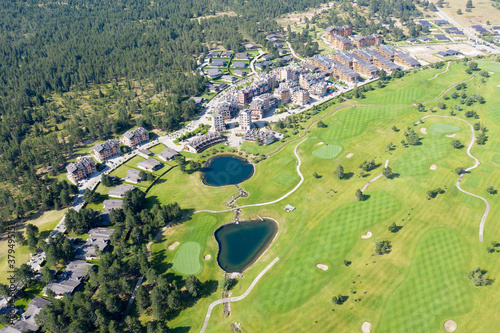 Aerial view from a drone. Stunning mountain views, hotels in the ski resort of Bansko, green golf courses in the morning at dawn. Travel and vacation concept photo