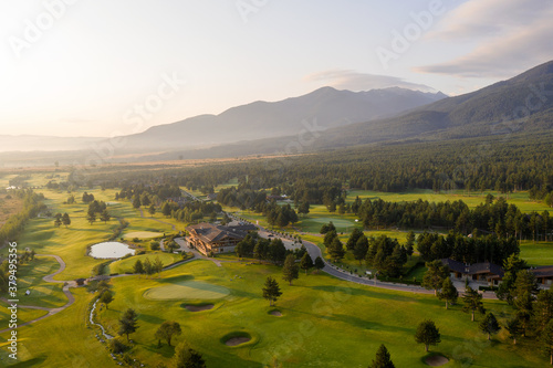 Fototapeta Naklejka Na Ścianę i Meble -  Aerial view from drone. Stunning view of mountains and hotels of mountain resort Bansko in morning at dawn. Beautiful landscape of sunrise in mountains is shot from drone. Travel and vacation concept.