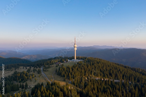 Aerial photo of a tv tower drone in sunset with fog on the mountain. Telecommunication tower on top of the mountain in Pomporovo, Bulgaria