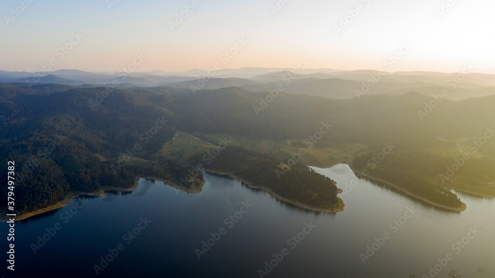 Scenic view of the mountains and the lake in the fog, Bulgaria. Mountain lakes surrounded by forests, aerial shot using a drone