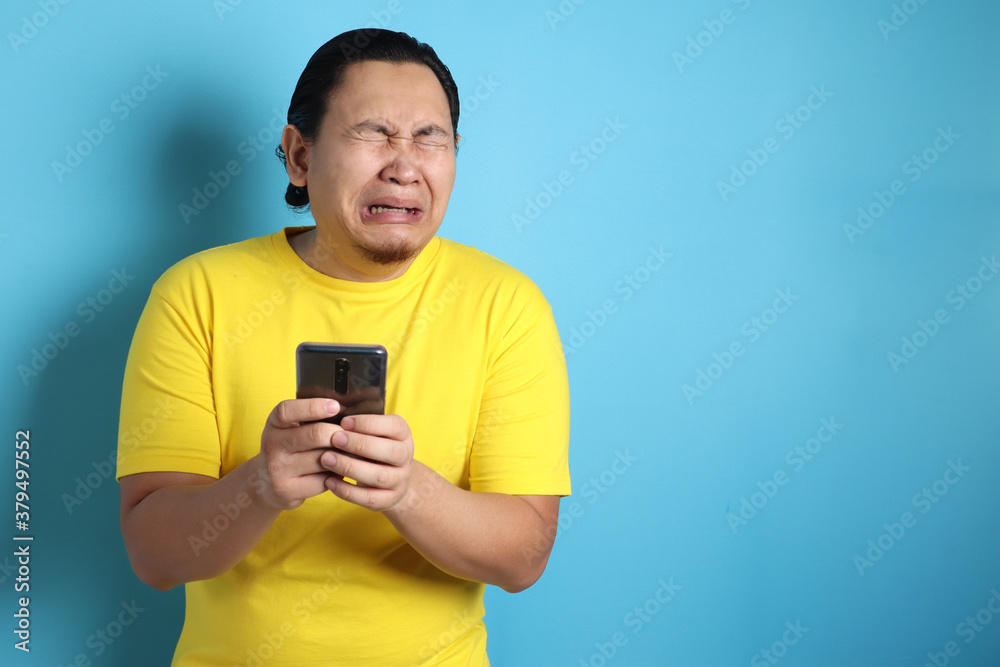 Young Man Texting Reading Chatting on His Phone Sad Crying Young Man Texting Reading Chatting on His Phone Sad Crying