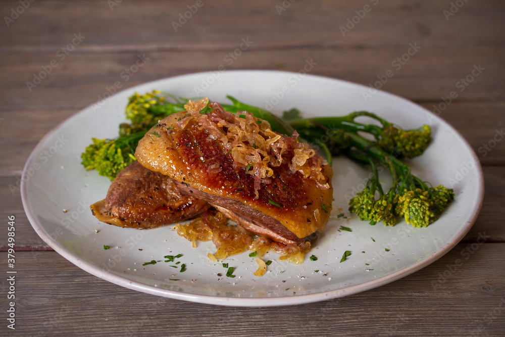 Roast duck breast fillets with vegetables on plate. vertical image Roast duck breast fillets with vegetables on plate. vertical image