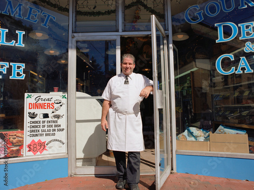 Middle-aged male deli owner standing in doorway photo