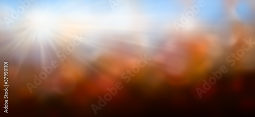 Herbstilich verschwommener Hintergrund mit Lichtstrahlen, Laubfarben und Himmel