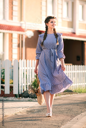 A young beautiful woman with a grocery bag with in her hands walking happy on the street.