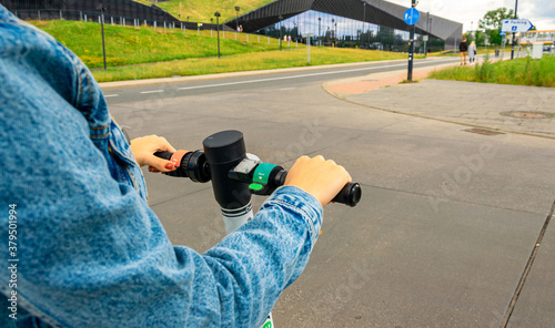 City scooter. Kick electric bike using from business woman. Public mobile transportation in European city center.