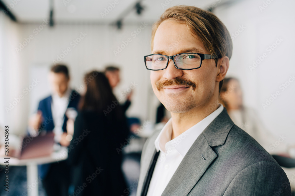 Portrait of smiling businessman standing in office seminar Portrait of smiling businessman standing in office seminar