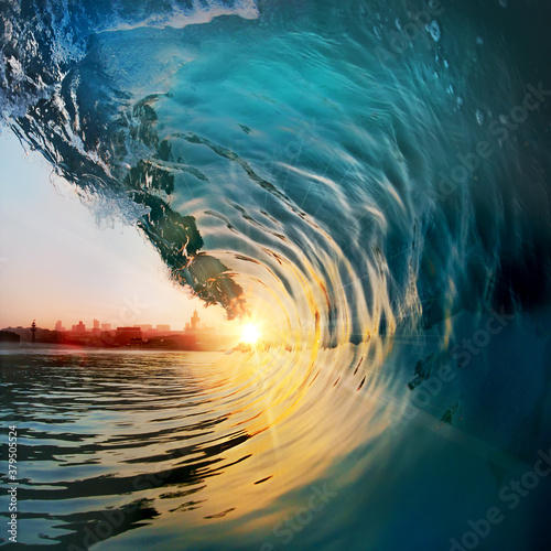 Beautiful ocean surfing shorebreak wave at sunset time. The sun inside of barrel photo