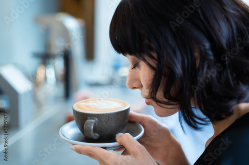 Quadro em tela Beautiful customer in cafe restaurant holding cup of latte art coffee