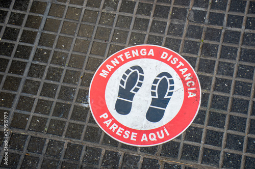 Footprint sign for stand at a distance, in the street of Buenos Aires, Argentina. Social distance word tag poster. Instruction against propagation. New normal. Social distancing during covid19